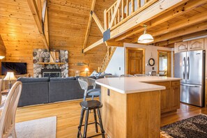 A wooden interior with a kitchen, dining area, and living room.