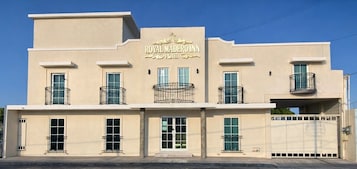 Un hotel con fachada color beige, balcones y un letrero que dice 'ROYAL MADEIRO INN'.