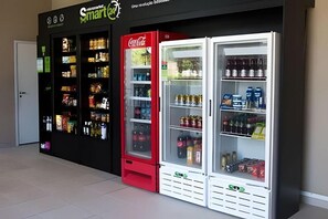 Ein Automatenbereich mit Coca-Cola-Automaten und einem Smart+24-Schild.