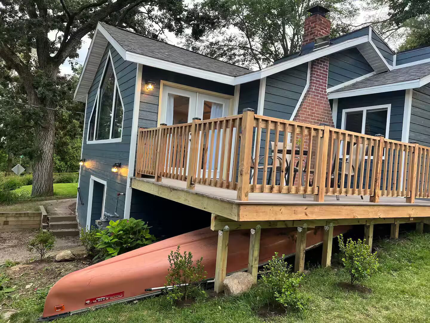 Een huis met een terras, schoorsteen en een garage.