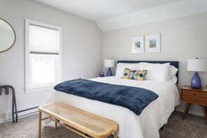 A bedroom with a bed, bedside tables, a bench, a window, and two framed pictures on the wall. - Beautifully renovated 2 bedroom, 1 bath charmer. (Frankfort)