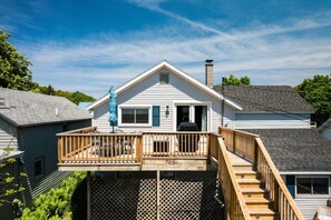 A two-story house with a deck, a chimney, and a number '706' on the front.