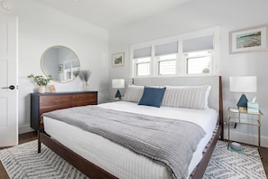 A bedroom with a bed, bedside tables, a dresser, a mirror, and framed pictures on the wall. - Frankfort In-Town Getaway (Frankfort)