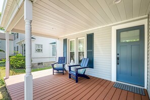 A covered porch with two Adirondack chairs, a blue door, and a white exterior wall. - Frankfort In-Town Getaway (Frankfort)