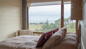 A bedroom with a large window, a bed, and a view of the countryside. - La Vertiente Pullay (Cobquecura)