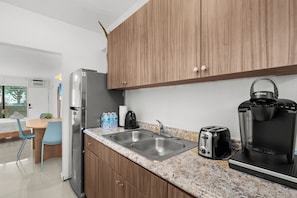 A modern kitchen with a stainless steel refrigerator, double sink, and coffee maker. - Charming studio apartment in delightful Miami Beach with cool AC (Miami Beach)