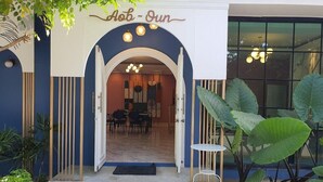 A building entrance with a sign reading 'Abo - Un' and a dining area inside. - Aob-oun Homestay By Zuzu (Pak Chong)