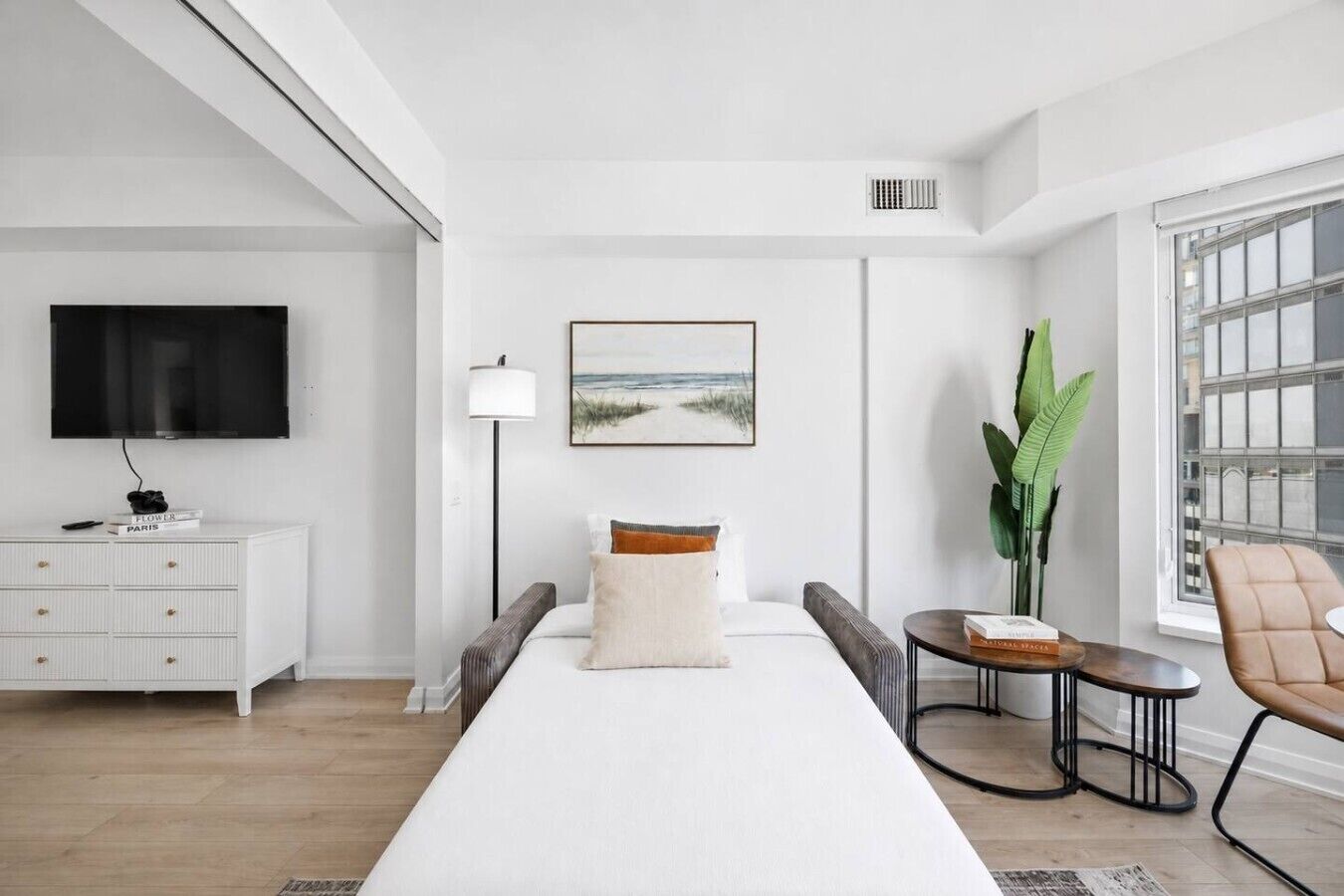 Een moderne hotelkamer met een groot bed, een televisie, een bureau en een raam met uitzicht.
