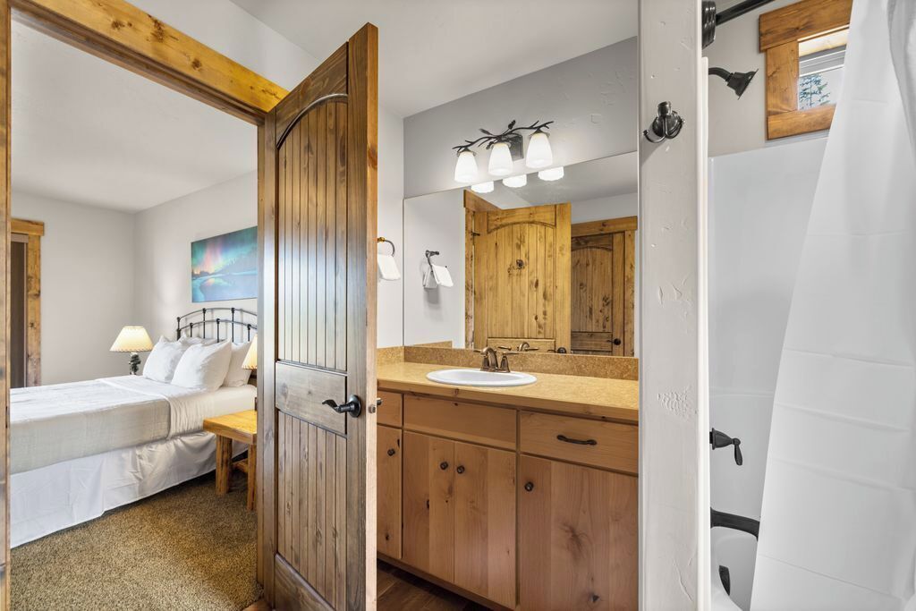 Een slaapkamer met een bed, nachtkastje en een schilderij aan de muur.
