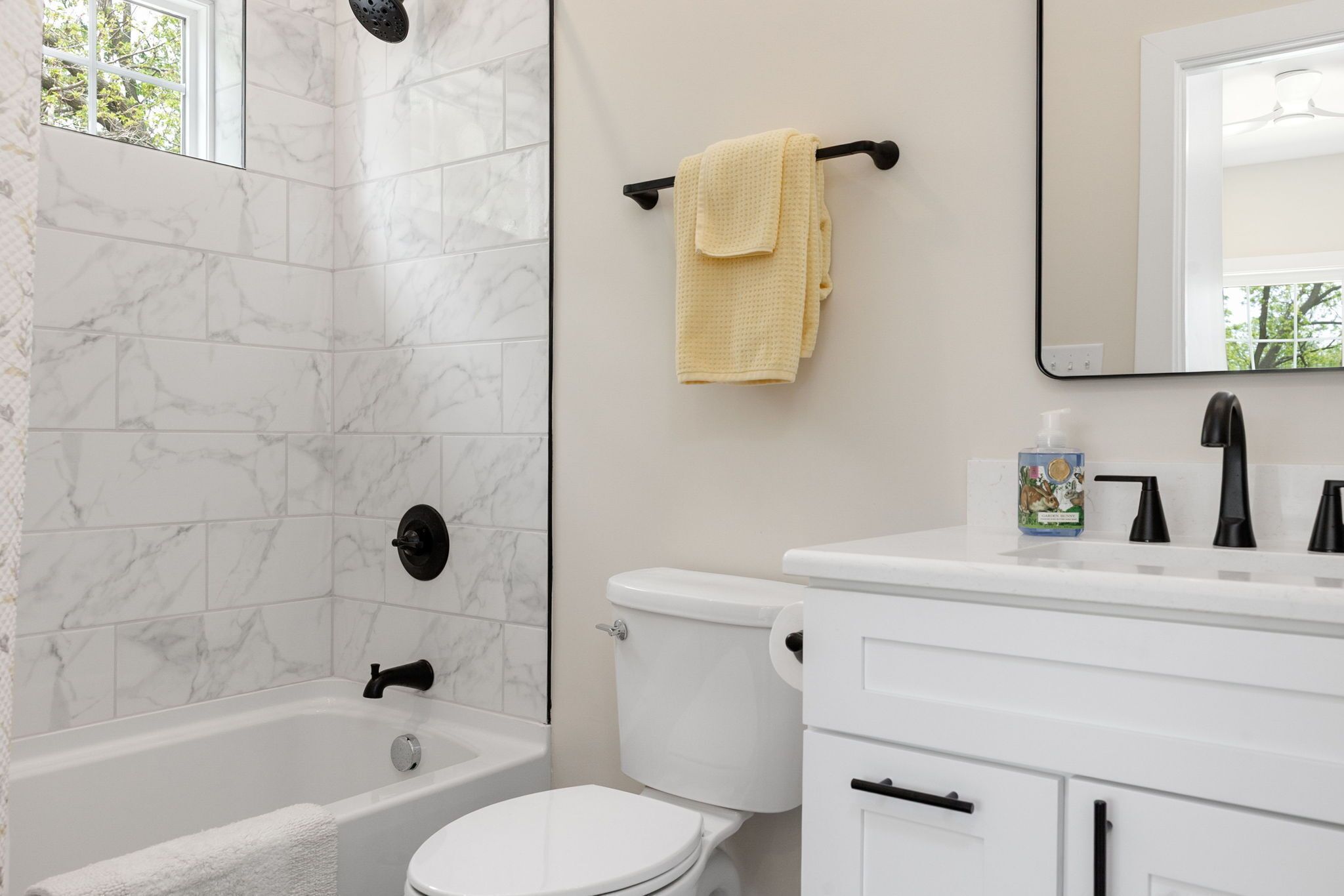 A bathroom with a bathtub, toilet, and sink.
