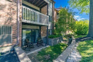 A two-story house with a balcony, a patio with chairs, and a well-maintained garden. - Dakmel Terrace Retreat (Southgate)