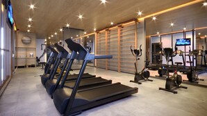 Ein Fitnessstudio mit Laufbändern, Ergometer und Gewichten.