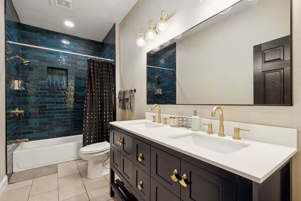 A bathroom with a bathtub, toilet, and a large mirror. - Dallas- Central Location, Spacious Backyard- Pets Welcomed (Dallas)