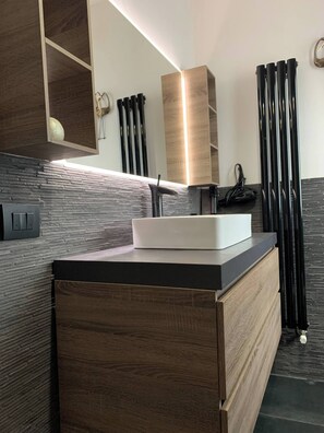 A modern bathroom with a wooden vanity, a white sink, and a mirror. - Penthouse 19 With Panoramic View (Montecatini Terme)