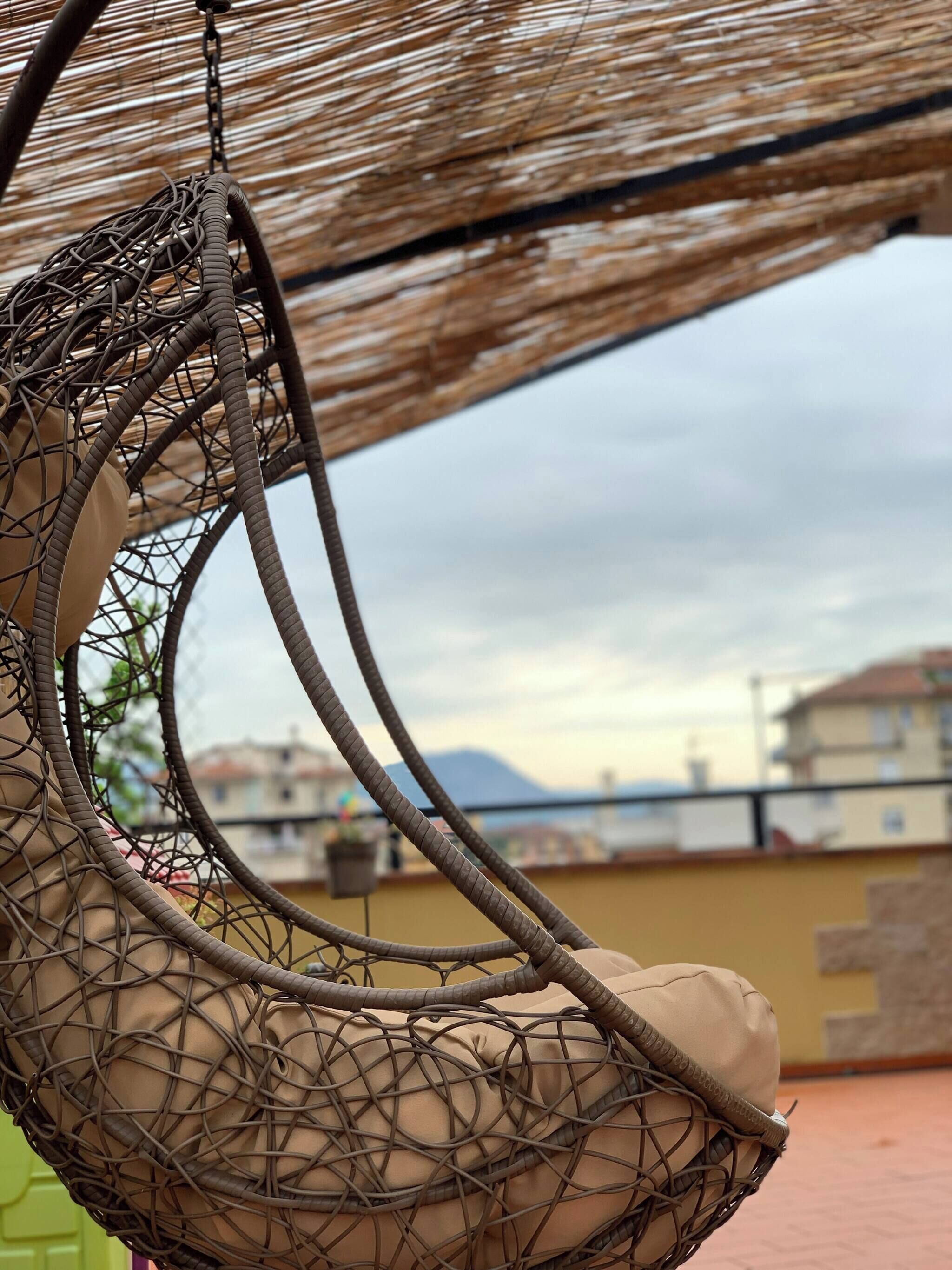 A hanging chair with a woven seat and backrest, attached to a metal frame.