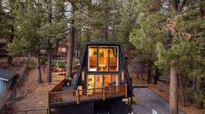 A cabin with a deck, large windows, and a staircase leading to the upper level. - Boutique Cabin, Across From Zoo, Mountain Views (Big Bear Lake)