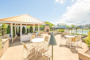 Eine Terrasse mit Pavillon, Grillplatz und Sitzgelegenheiten.
