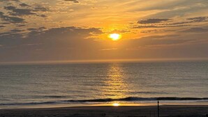 Um pôr do sol sobre o oceano, com céu limpo.