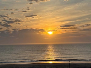 Ein Sonnenuntergang über dem Meer bei klar blauem Himmel.