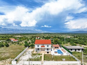 A two-story building with a red roof, a swimming pool, and a view of distant mountains. - Villa Vera-swimming pool, 12 PAX (Donji Kašić)