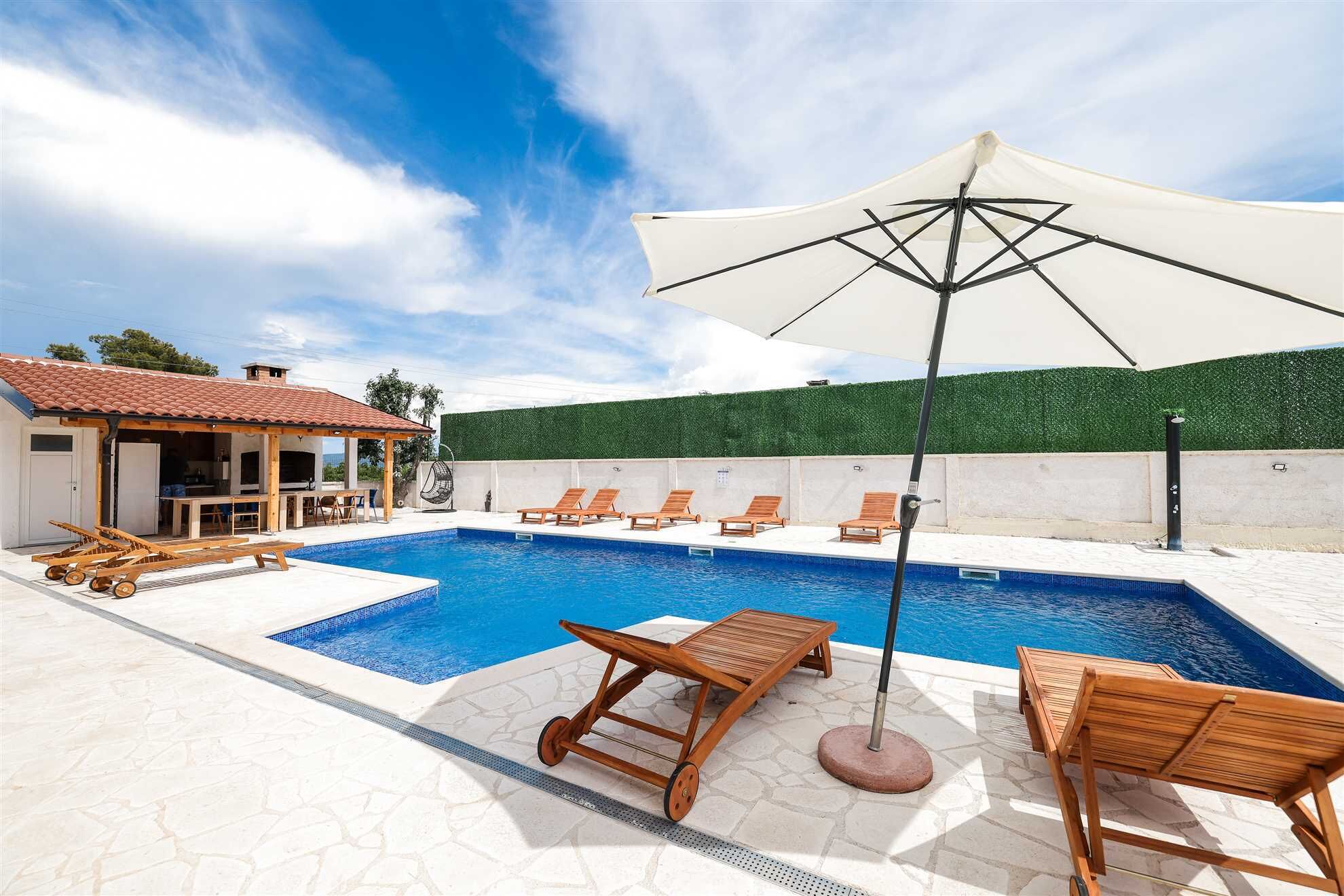 A swimming pool with lounge chairs and a pergola.