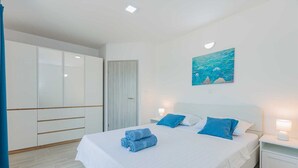 Ein Schlafzimmer mit einem Bett, einem Nachttisch, einem Gemälde und einem Kleiderschrank.