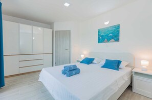 A bedroom with a bed, a nightstand, a painting, and a wardrobe. - Villa Vera-swimming pool, 12 PAX (Donji Kašić)