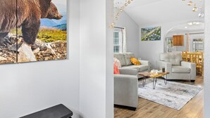 Ein Wohnzimmer mit einem Bärenbild, einem Sofa, einem Couchtisch und einer Chandelier.