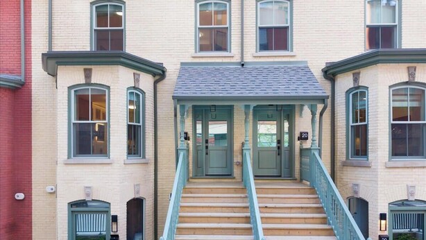 A building with a central staircase, multiple windows, and doors numbered 18, 19, and 20.