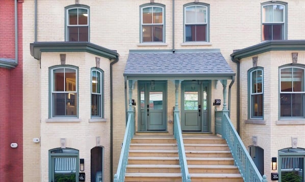 A building with a central staircase, multiple windows, and doors numbered 18, 19, and 20. - Boutique Townhouse • 3BR • Sleeps 7 • Free Parking (Toronto)