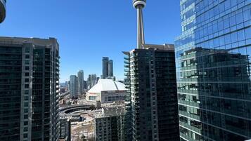 A high-rise building with a view of the CN Tower and a stadium.