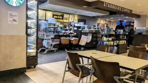 Uma loja Starbucks Coffee com área de estar, balcão e exposição de produtos.