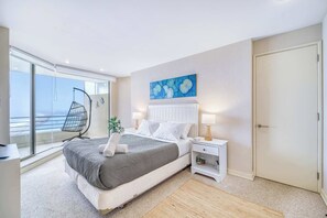 Una camera da letto con un letto, un comodino, una sedia e vista sull'esterno.