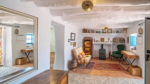 Un intérieur rustique avec une cheminée, des meubles en bois et un miroir qui reflète la pièce.