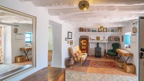 Ein rustikales Interieur mit Kamin, Holzmöbeln und einem Spiegel, der den Raum widerspiegelt.