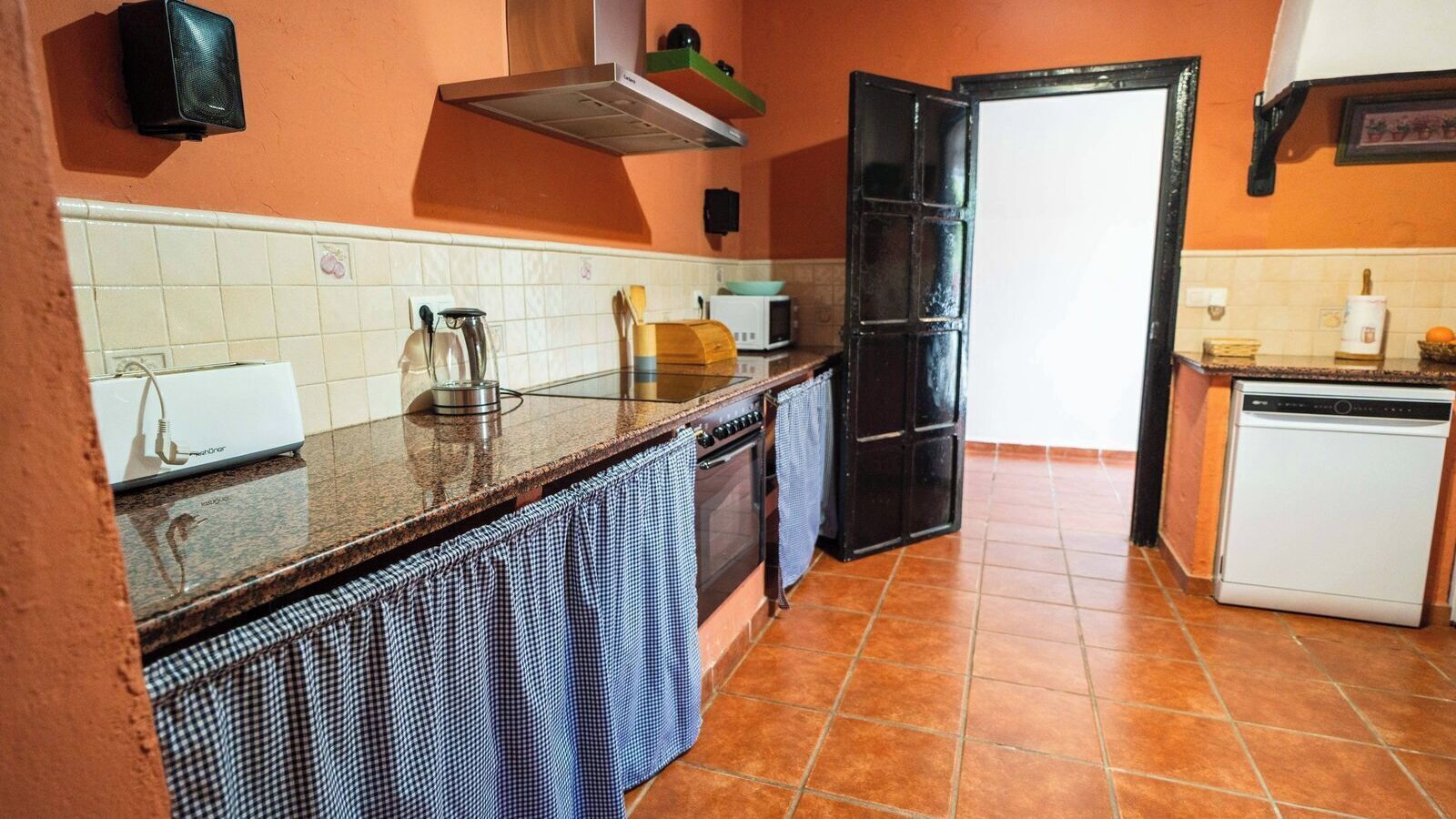 A kitchen with a microwave, toaster, and a dishwasher.