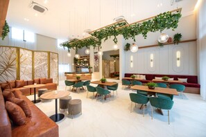 Decoração moderna com área de estar, mesas e plantas penduradas.