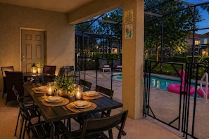An outdoor dining area with a pool and inflatable rings. - Near Disney & Epic 5BR w/ Pool & Game Room (Davenport)