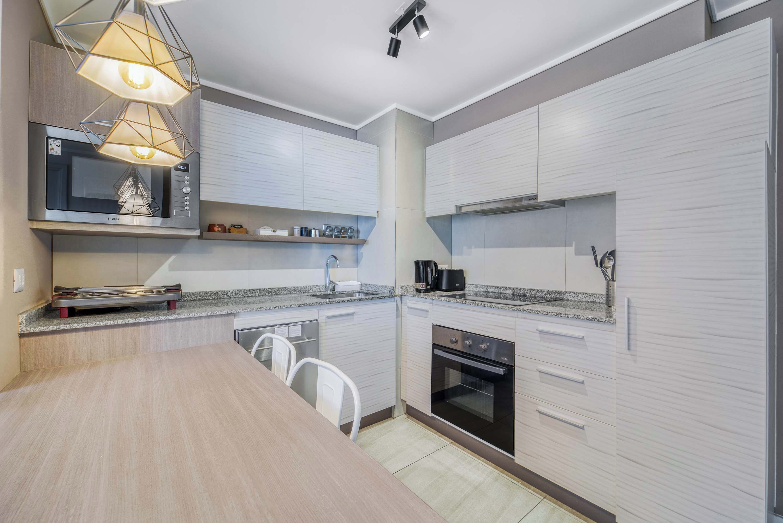 A modern kitchen with a microwave, oven, and built-in cabinets.