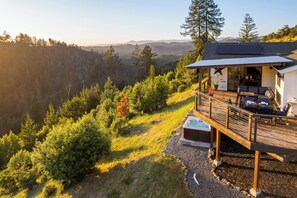 A cabin with a deck, a hot tub, and a view of a forested valley. - Alta Mayacama | Views, Hot Tub, Plunge Pool (Santa Rosa)