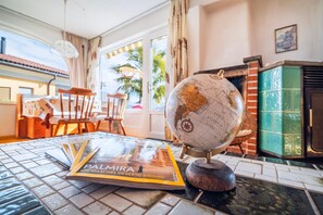 A room with a globe, a book titled 'Palmera Un Oasi nel Deserto Siriano,' and a fireplace. - Lugano Horizon Retreat (Bigorio)