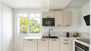 Una cucina moderna con forno a microonde, macchina del caffè e forno.