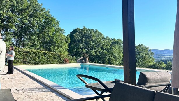A pool area with lounge chairs, a covered seating area, and a view of the surrounding landscape. - Annex House with Pool   InBorgo (MONTECASTRILLI)