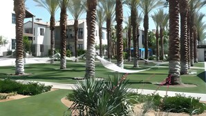Un complexe hôtelier doté de palmiers, d’un parcours de golf et de bâtiments modernes.