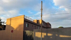 A building with a gated entrance, a stop sign, and a utility pole. - Hotel Betel 3 pontes (Itaboraí)
