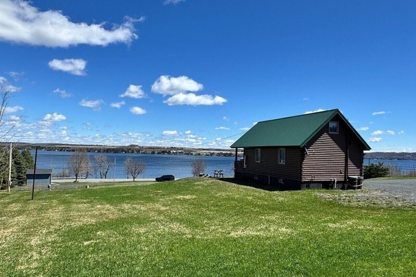 Exterior | Log Cabin Design & Green Metal Roof | Open Lakeside Landscape