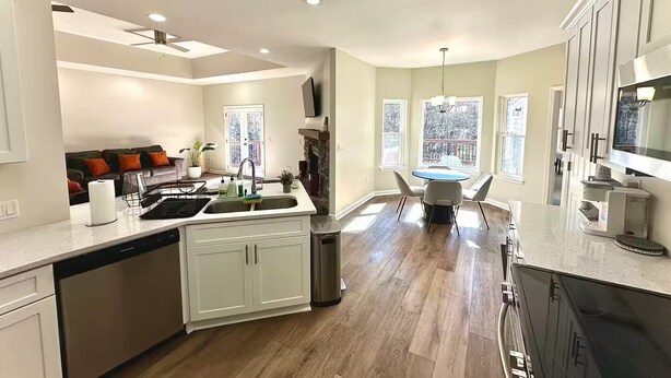 Una cocina moderna con una isla central, electrodomésticos integrados y ventanas amplias.