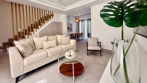Un salon moderne avec un canapé, une table basse et une grande plante.