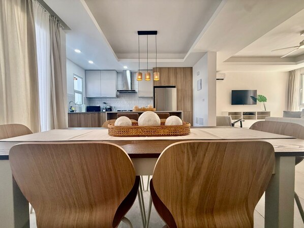 Un coin repas moderne avec une table en bois, deux chaises et un élément décoratif central.