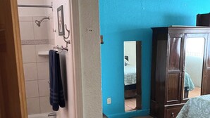 Een badkamer met een bad, een douche en een handdoekrek.